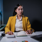 Pretty happy young entrepreneur woman working with laptop sitting in the office at night.